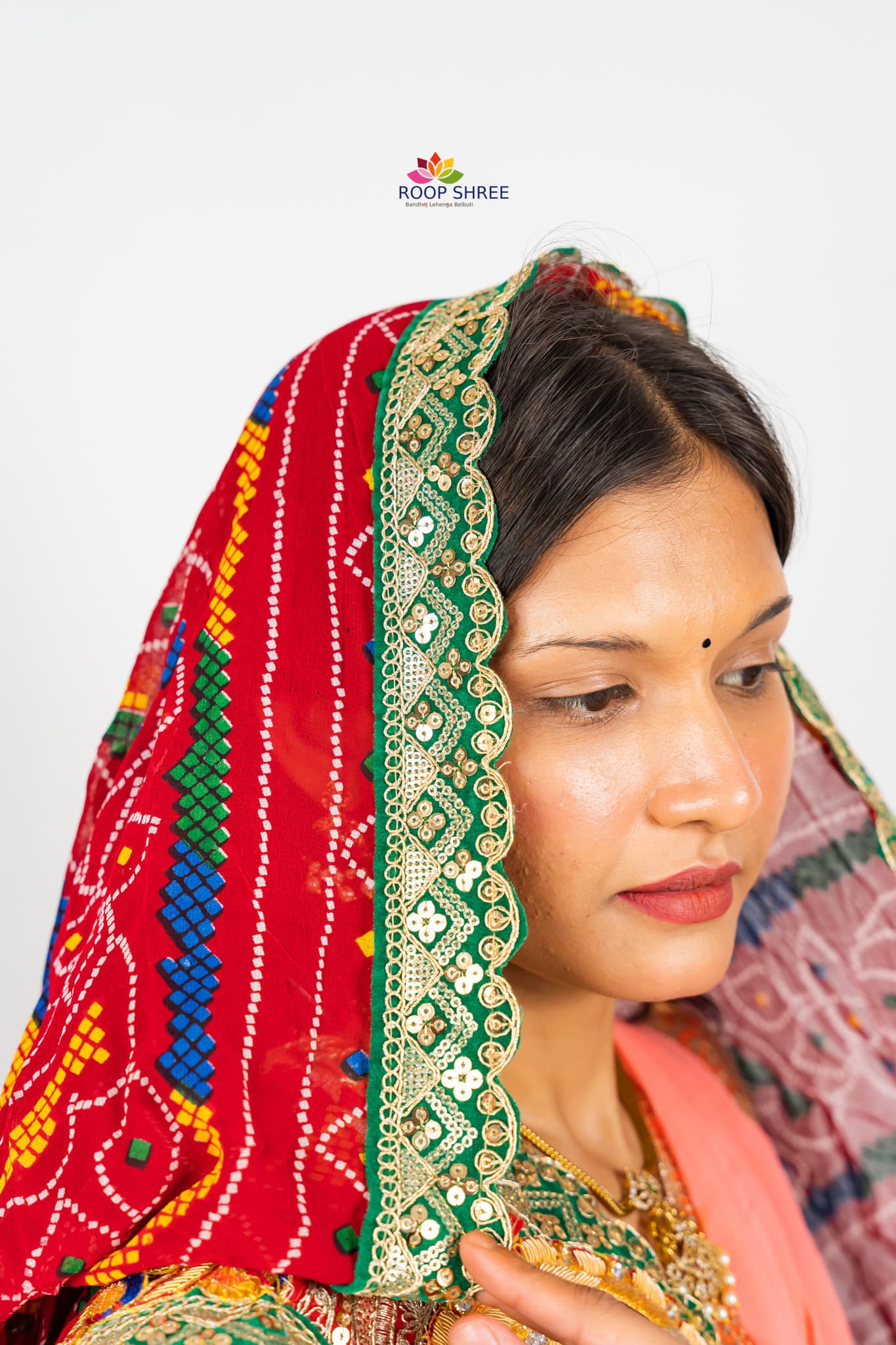 Elegant odhna with one-side brooch featuring Swastik Belbuti work.